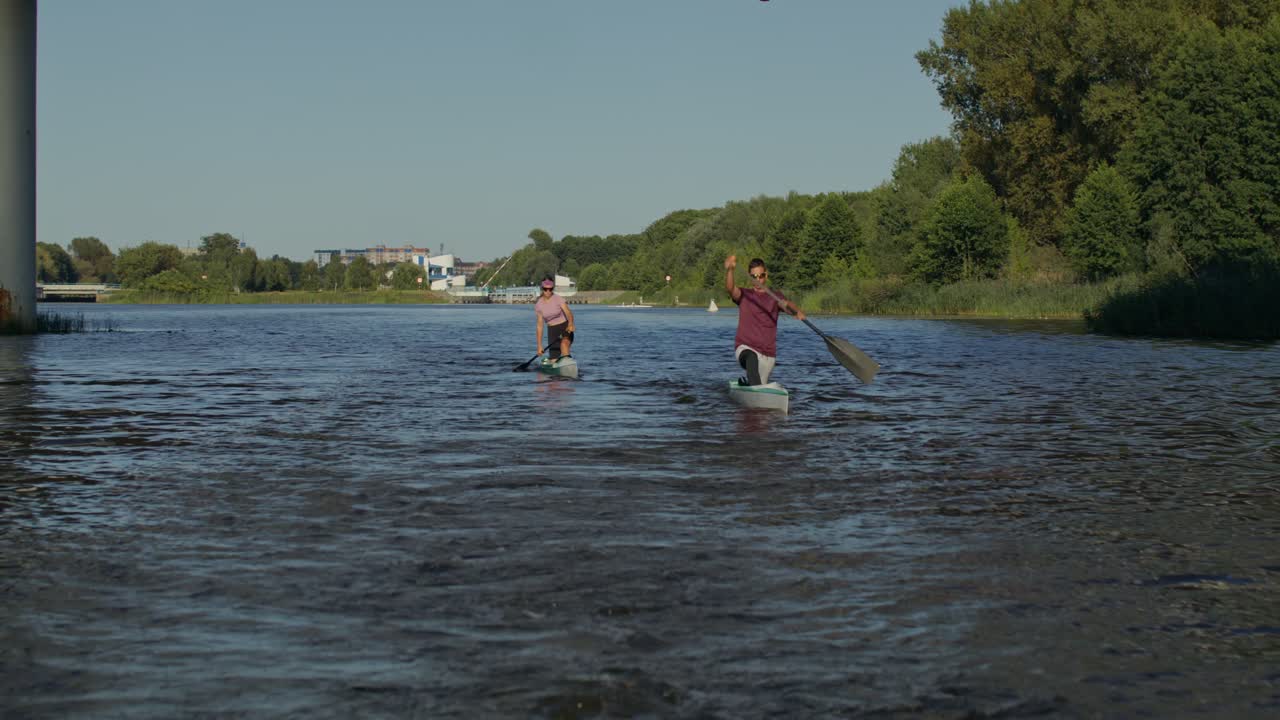Folk står op og paddleboarder på en flod