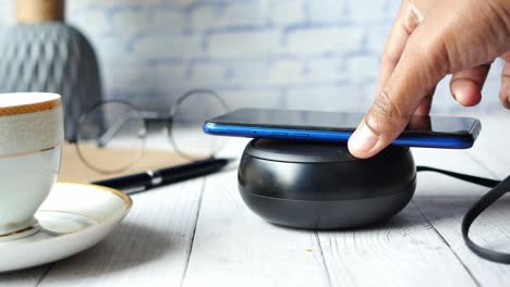 cargar el teléfono inteligente con una almohadilla de carga inalámbrica, de cerca