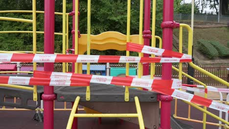 un juego de diapositivas cerrado con cintas y barreras visto en un parque público debido al brote de coronavirus covid-19 y restricciones en hong kon