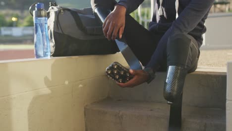 Disabled-mixed-race-man-checking-his-prosthetic-legs-