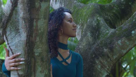 Curly-hair-girl-sits-in-a-tree-while-enjoying-a-sunny-day