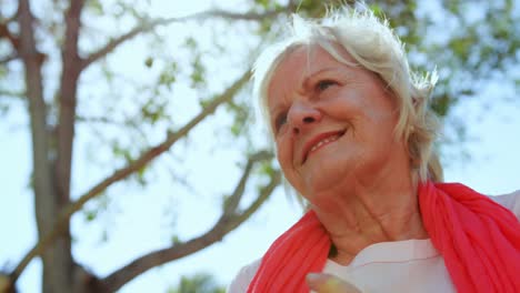 Low-angle-view-of-active-Caucasian-senior-woman-performing-yoga-in-the-garden-of-nursing-home-4k