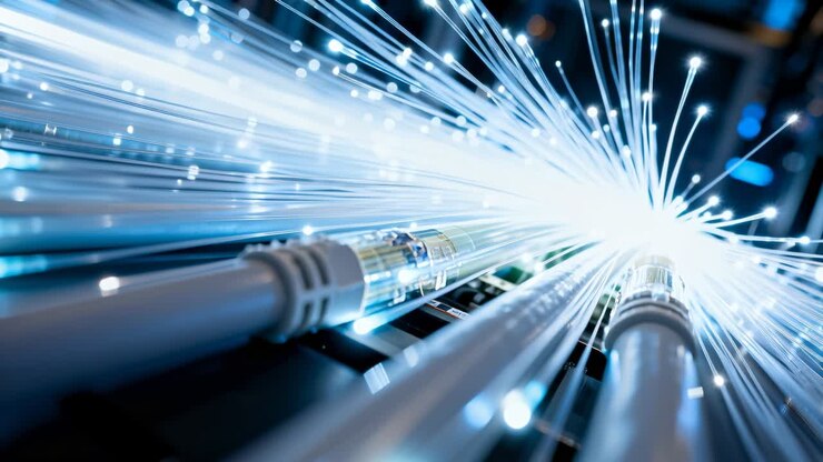 Zooming dolly pushing fiber-optic patch cables forward in rack, revealing brightening fiber tips