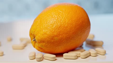 vitamin c tablets dropping on white surface beside orange, slow motion with motion blur