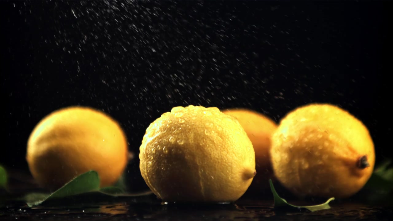 Primo piano di limoni freschi con goccioline d'acqua su sfondo scuro.