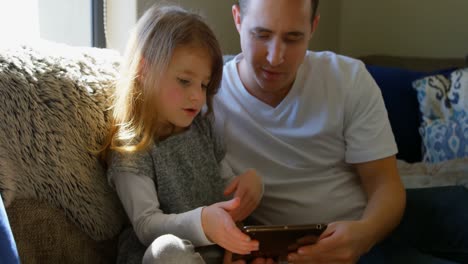 Vater-Und-Tochter-Nutzen-Digitales-Tablet-Im-Wohnzimmer-4K