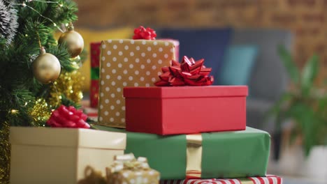 video of christmas tree with stack of wrapped presents at home