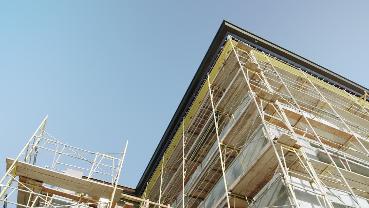 Building under construction with scaffolding against a blue sky