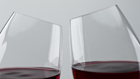 alcohol red drink clinking wineglasses closeup. cheering rose wine clear glasses