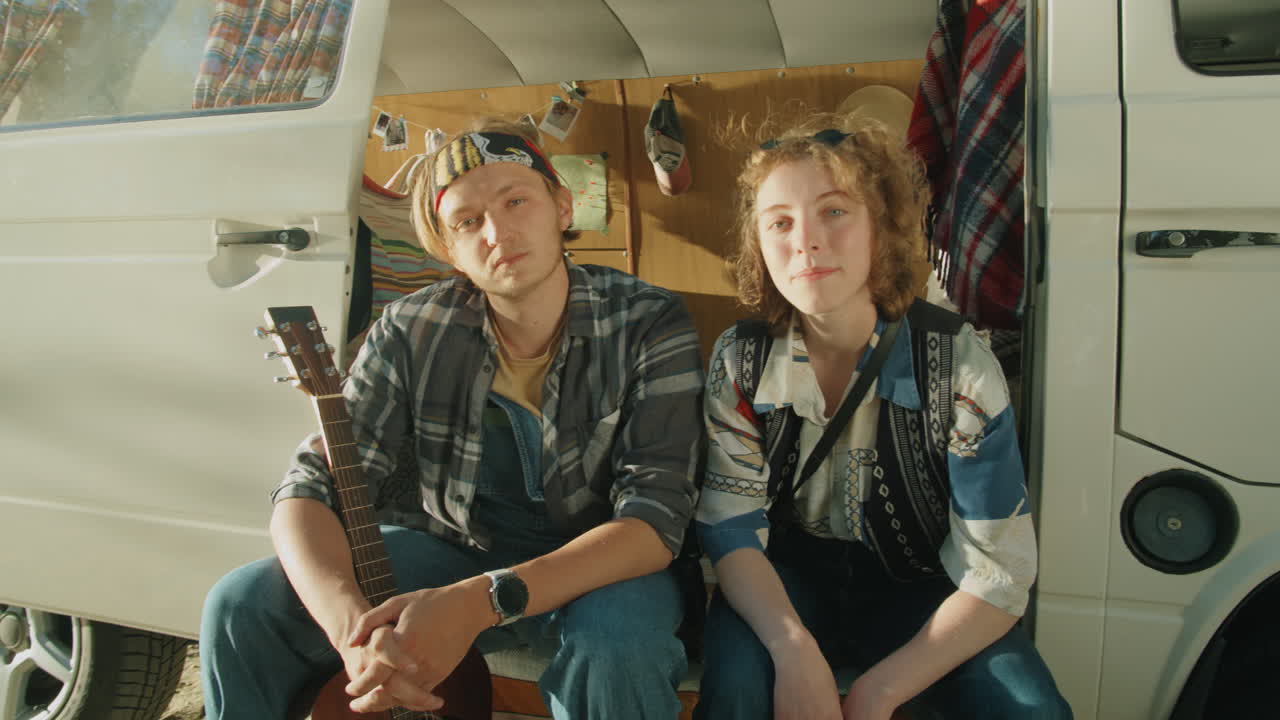 молодой мужчина и женщина позируют для камеры в фургоне