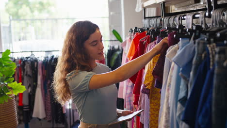 propietaria o trabajadora de una tienda de ropa de moda comprobando el stock con una tableta digital