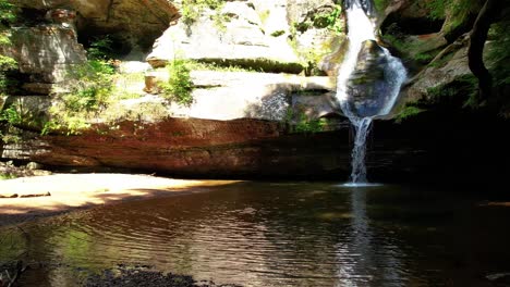 disparo suave de drones empujando sobre el agua y hacia una cascada