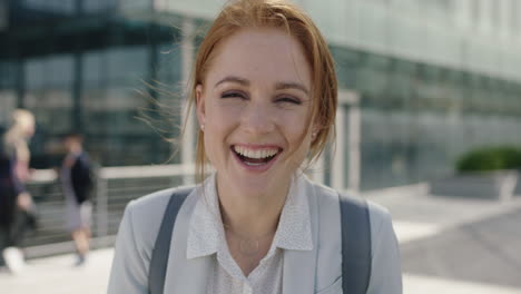 close up portrait of happy red head business woman intern laughing cheerful enjoying corporate career in city