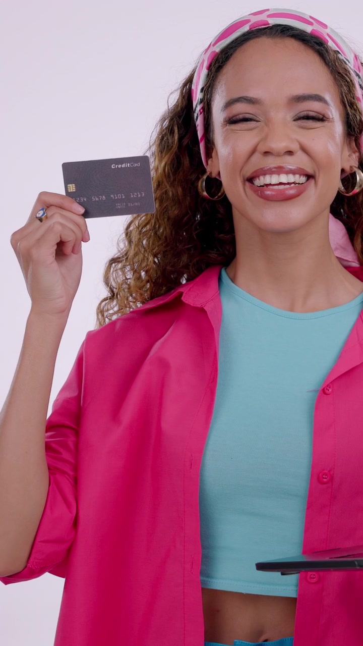 Young Woman Holding Credit Card and Smiling at Camera