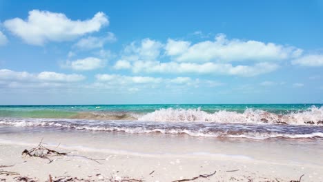 A beautiful tropical beach scene at Holbox Punta Cocos, Mexico, featuring calm ocean waves and clear skies