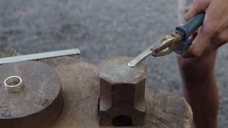 proceso de moldeo de plata forjada con martillo por un joyero