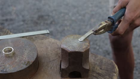 proceso de moldeo de plata forjada con martillo por un joyero