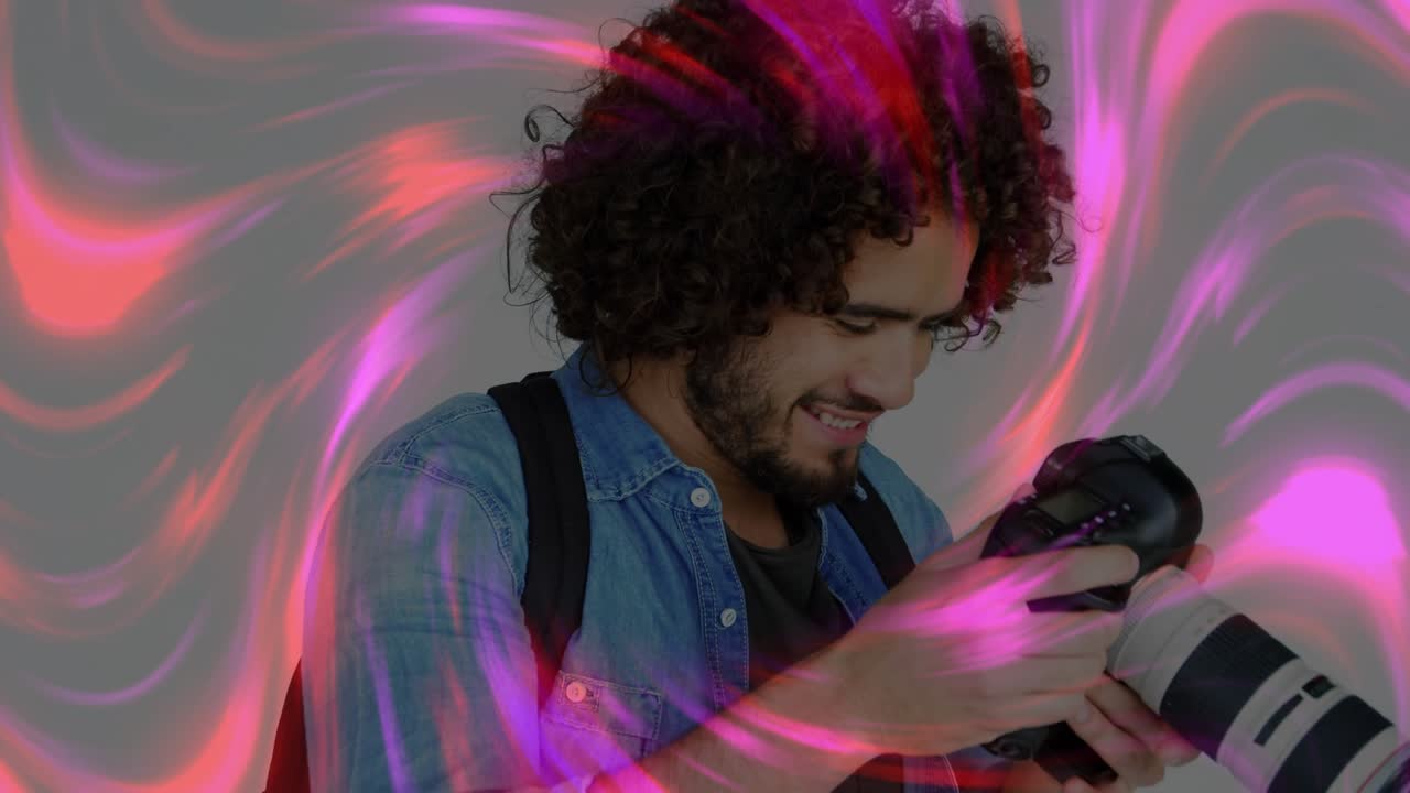 Løfter et DSLR-kamera, som utløser virvlende rosa og røde lys rundt fotografen som senker kameraet og går gjennom bildet.