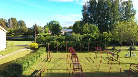 Climbing-ladder-and-small-outdoor-gym-in-local-park,-close-up-ascend-view