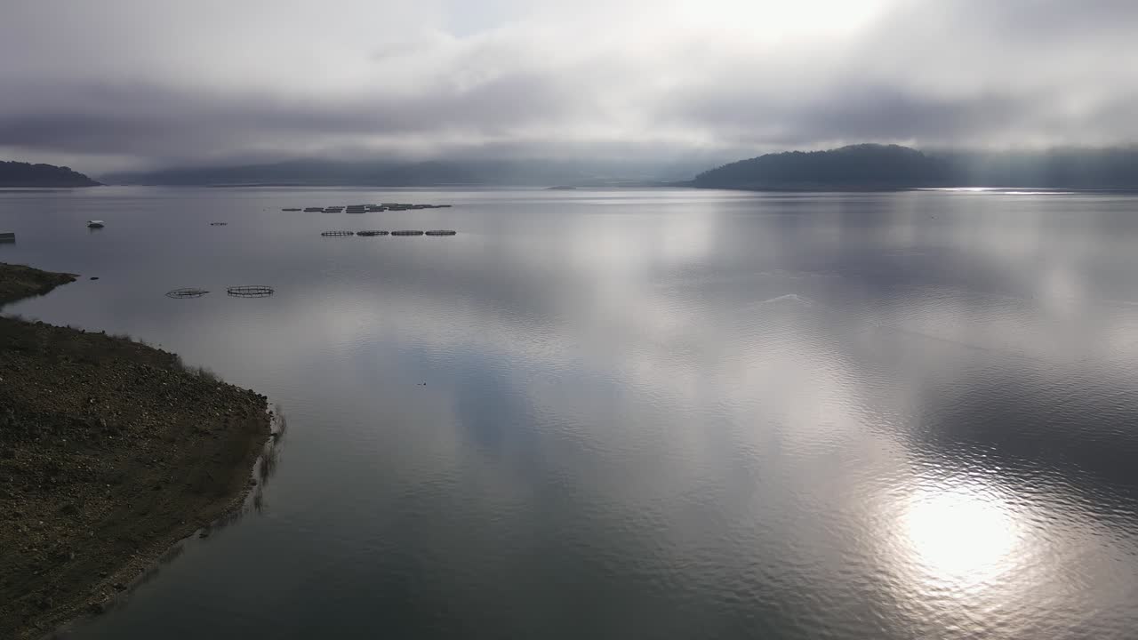 원형 케이지 를 가진 어류 농장 을 가진 산 의 호수 위 의 공중 비행