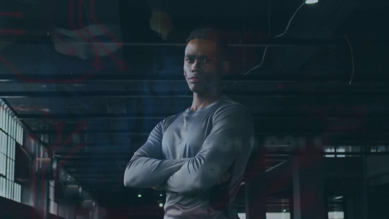 Fitness pro entering frame, crossing arms, holding pose while light bars accent form showing power