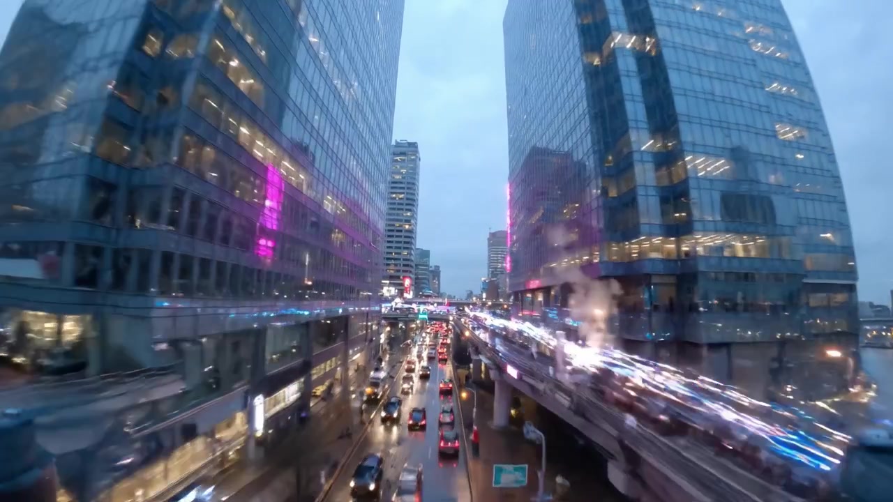 Paesaggi urbani vivaci al tramonto con edifici illuminati, strade animate e riflessi sull'asfalto bagnato, che creano un'atmosfera e una vita urbana dinamica.