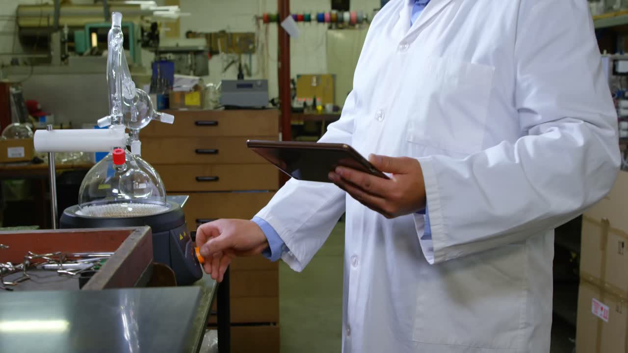 Trabajador usando una tableta digital en una fábrica de vidrio 4K.