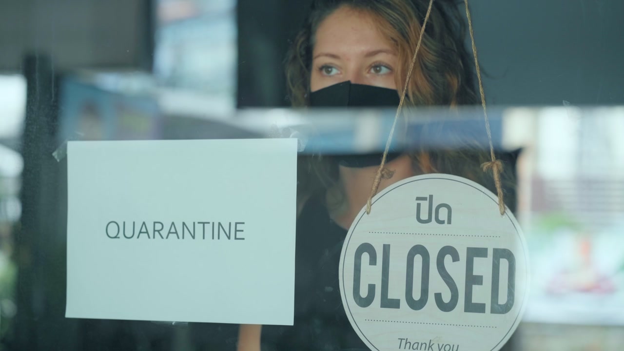 Woman Wearing Face Mask Looking Through Closed Shop Window