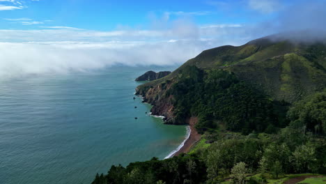 aerial view flying along the marin headlands, sunny day with fog in calfornia, usa