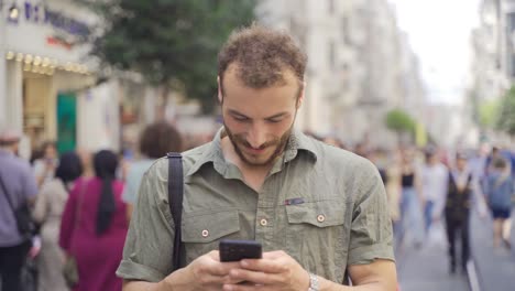 enviando mensajes de texto por teléfono en la calle de la ciudad.