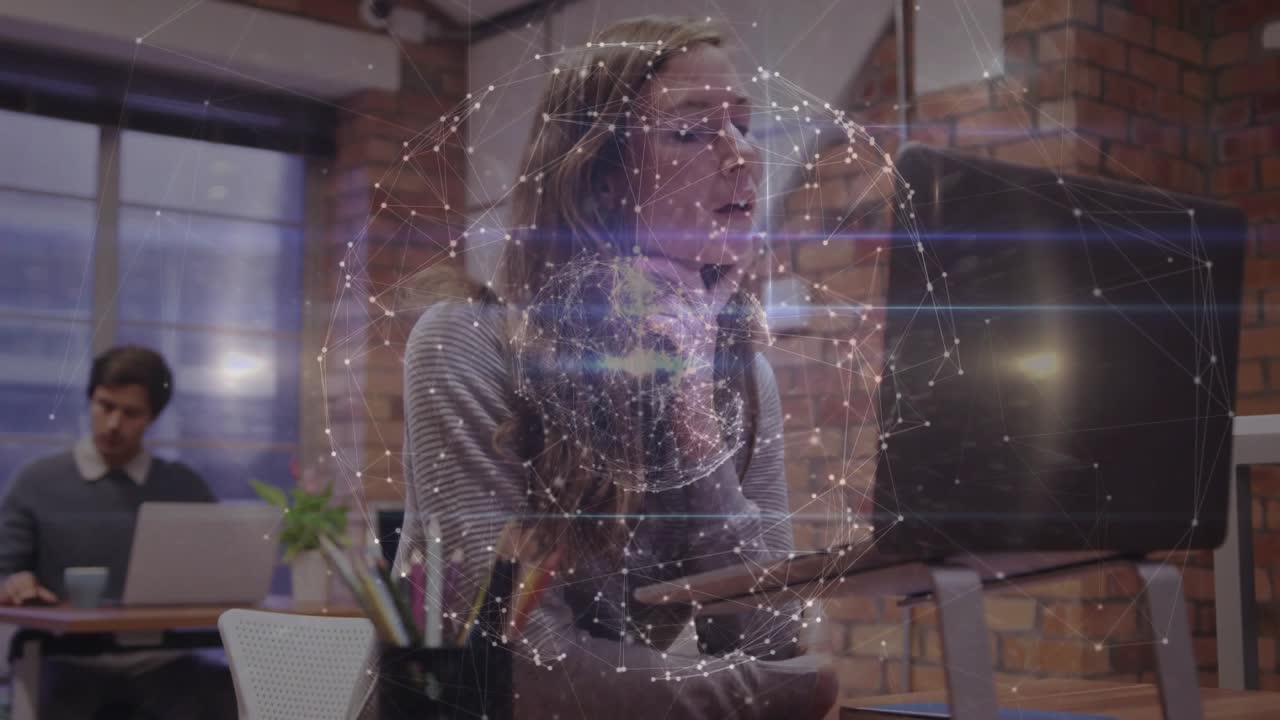 Donna appoggiata alla tastiera e che interagisce con il monitor, gestendo un'animazione di un globo tecnologico per la visualizzazione dei dati.