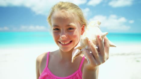 portrait of girl on beach with conch shell