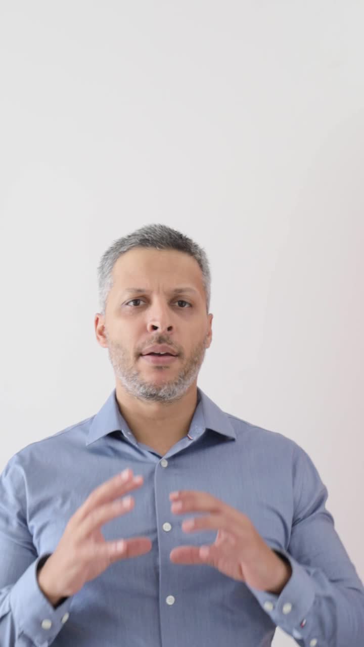 Uomo d'affari che spiega gesticolando su sfondo bianco