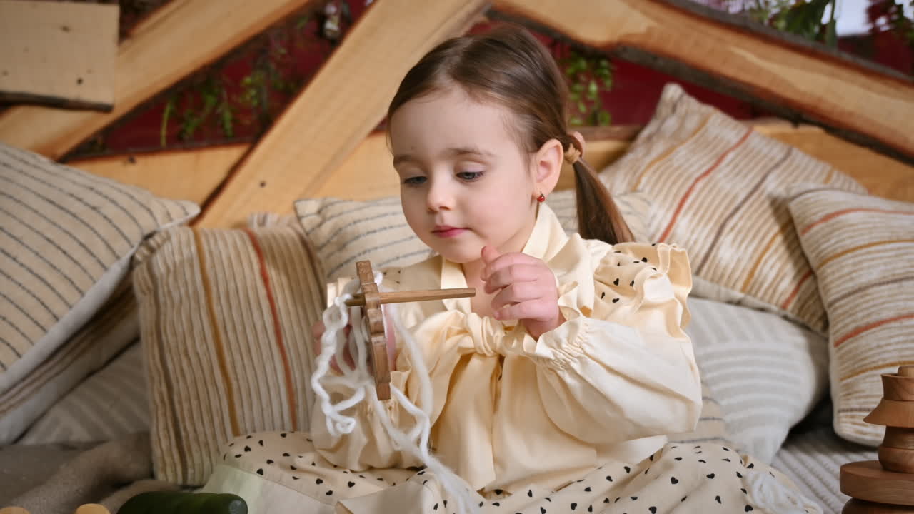 Little girl playing with a wooden lacing sheep. Ecological and sustainability concept