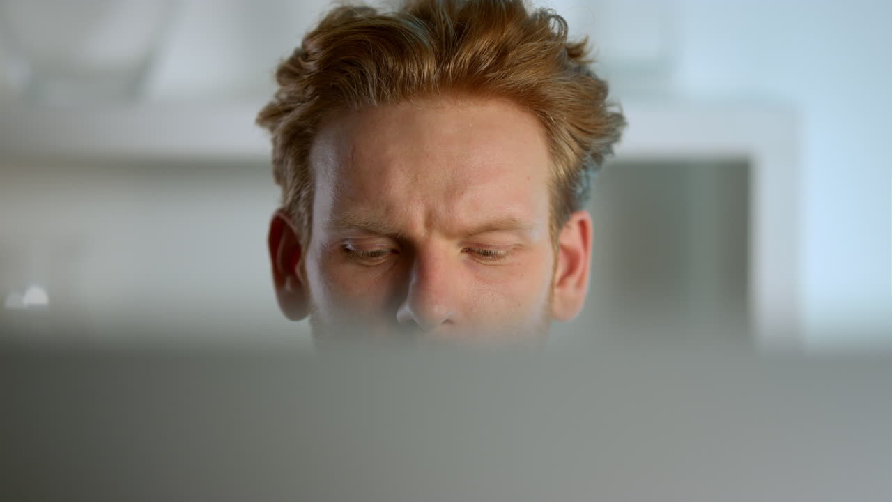 freelancer trabajando en una computadora de escritorio en la oficina. gerente de jengibre enfocado.