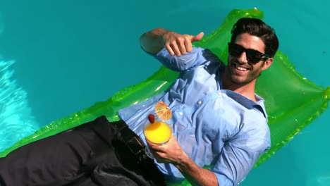 happy businessman showing a thumbs up in the swimming pool