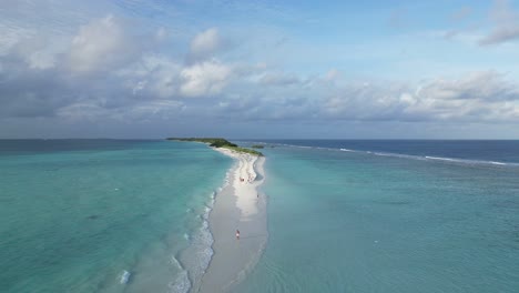 holiday-maker people relaxing on sandbank of dhigurah island with its white sand and aqua blue lagoon, maldives