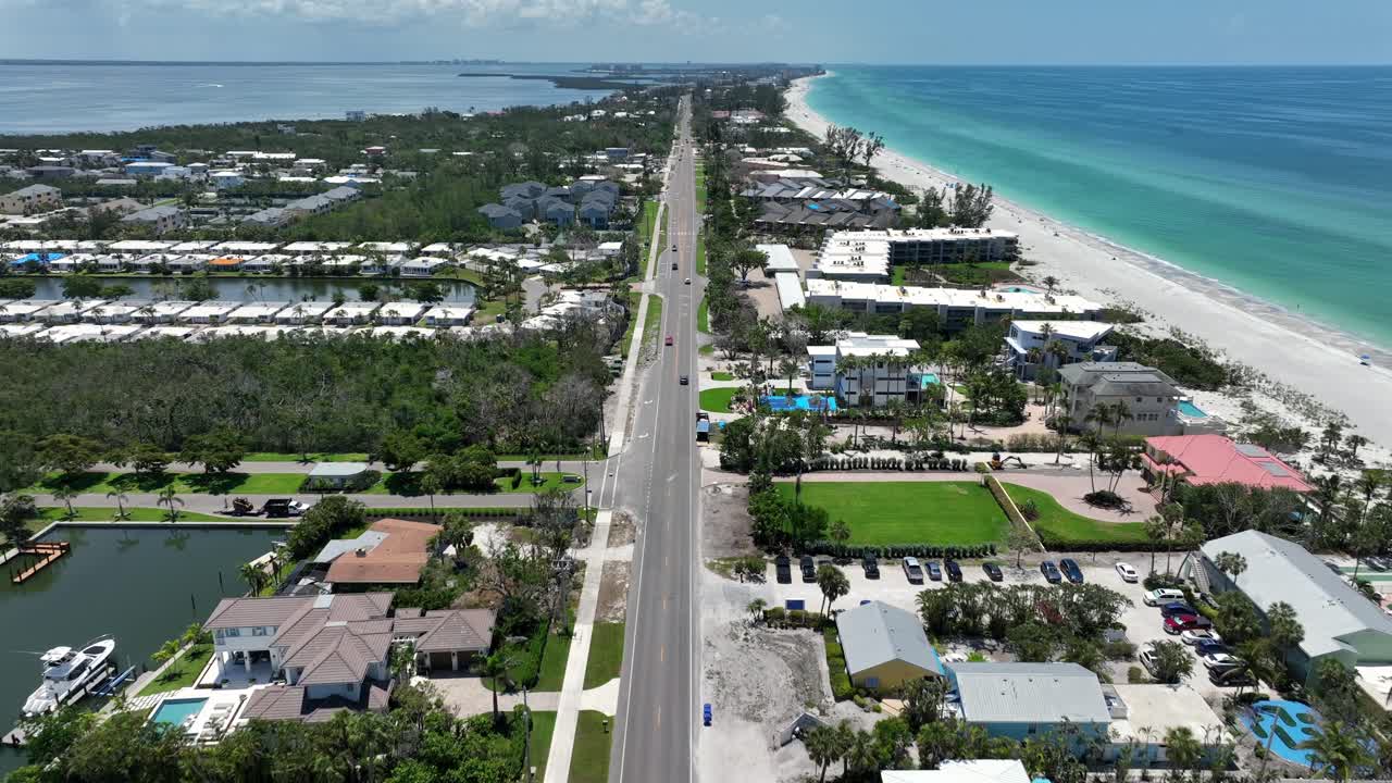 Traffic on Main Street in coquina beach, Florida. Aerial Birds Eye shot. Sunny day, clear sky and water of ocean in America. Luxury houses and homes in USA. Wide shot