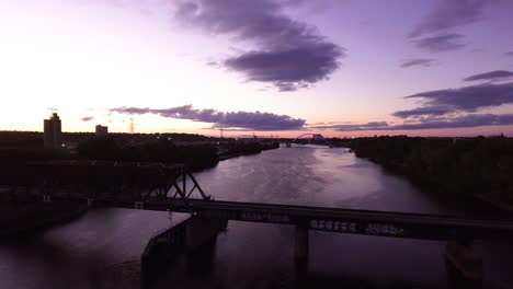 Magische-Stunde-Luftaufnahme-Einer-Eisenbahnbrücke-über-Den-Mississippi