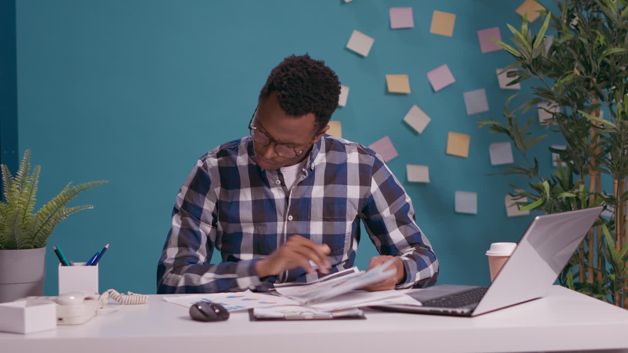 African american person analyzing business charts on documents