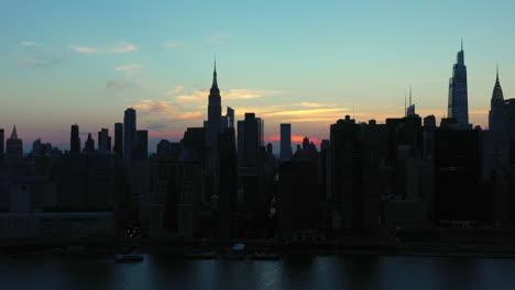 aerial tilt up over the legendary manhattan skyline at dusk