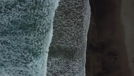 Vídeo-Aéreo-De-Drones-Mirando-Hacia-Abajo-Sobre-La-Playa-Negra-Volcánica-Y-Las-Olas-En-El-Mar-Azul-Profundo