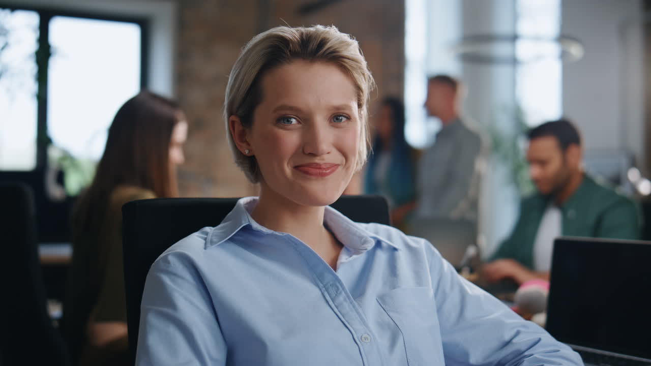 Gorgeous businesswoman smiling camera sitting office coworking with team closeup