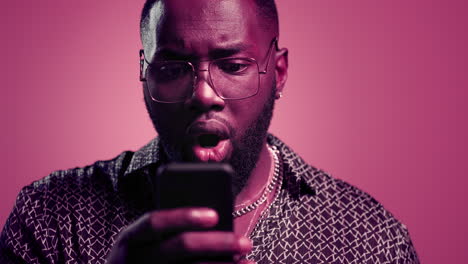 African-american-getting-good-news-in-studio.-Afro-guy-reading-message-indoors