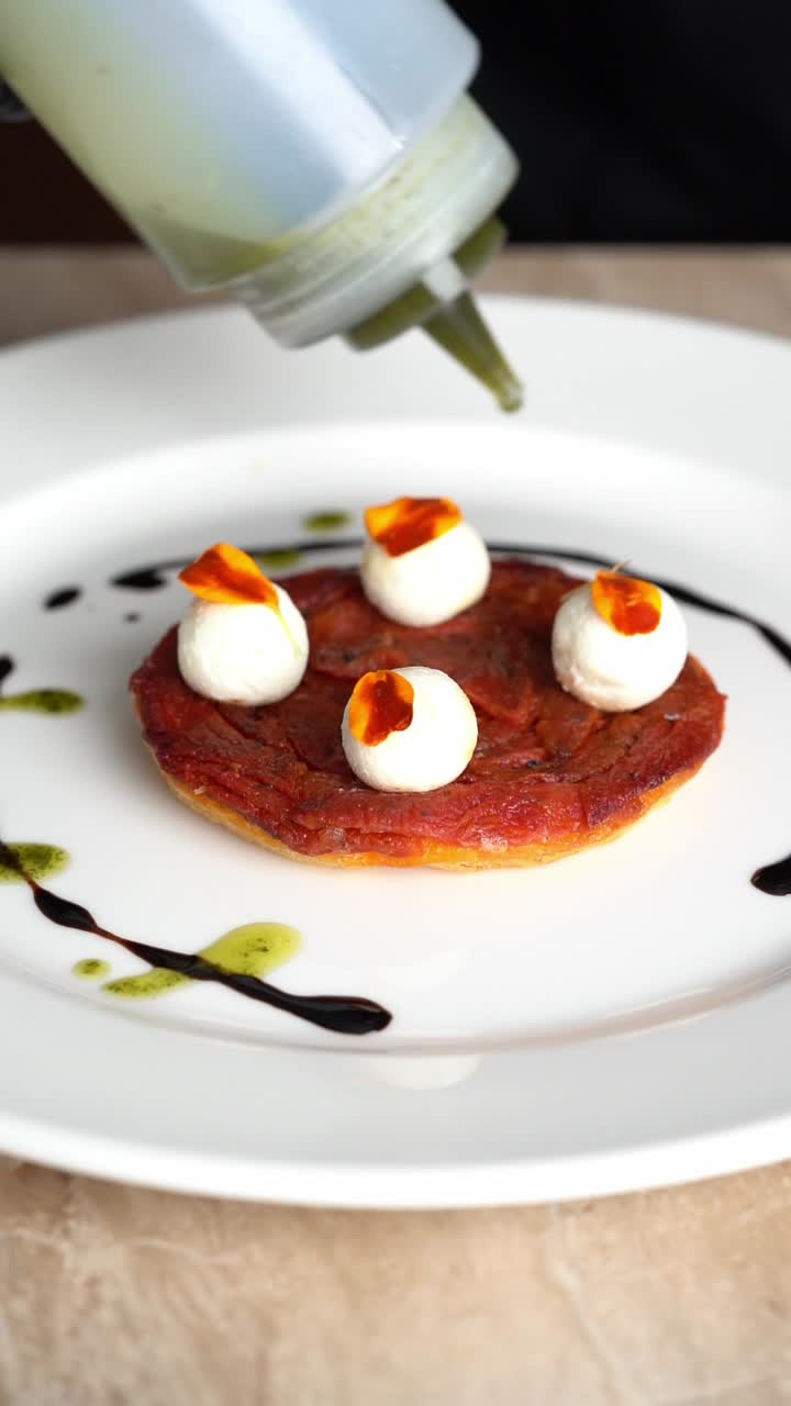 Chef Plating Gourmet Appetizer with Mozzarella and Green Sauce