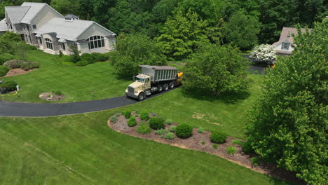 Aerial-rising-shot-of-paving-company-paving-new-asphalt-driveway