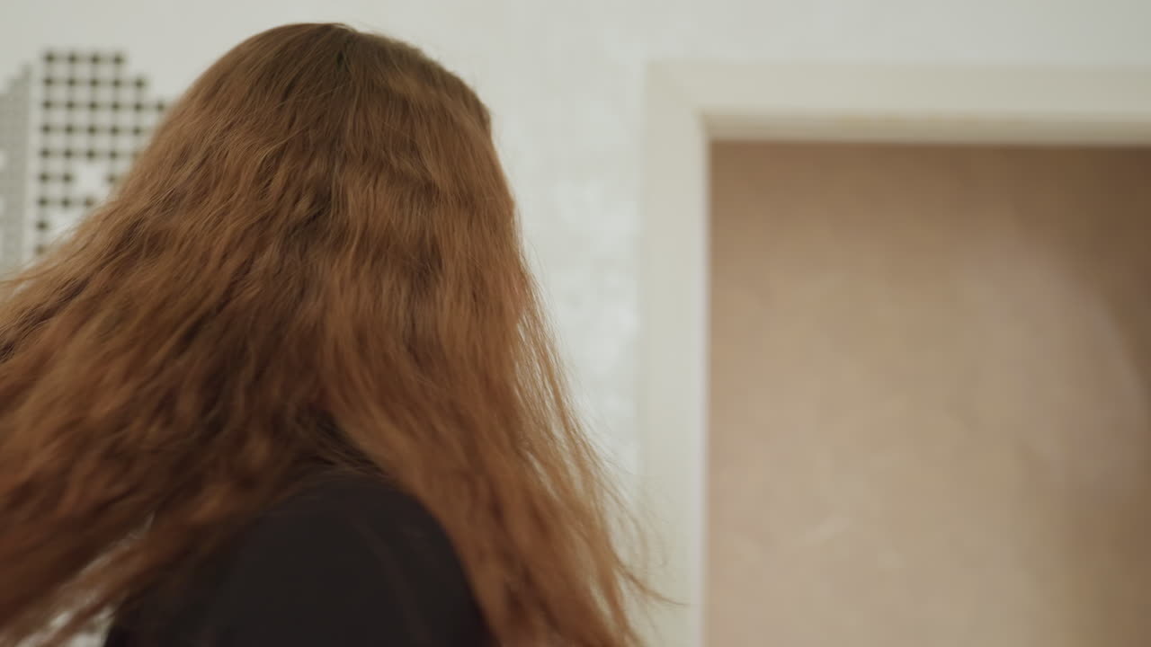 Elegant woman enters room with confidence, long hair flip, stylish turn and warm smile, black zipper dress, casual indoor scene, doorway background, poised model showcasing outfit, playful stride