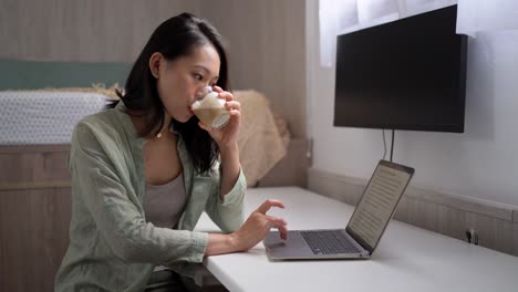 Asian-writer-with-laptop-and-coffee-at-home