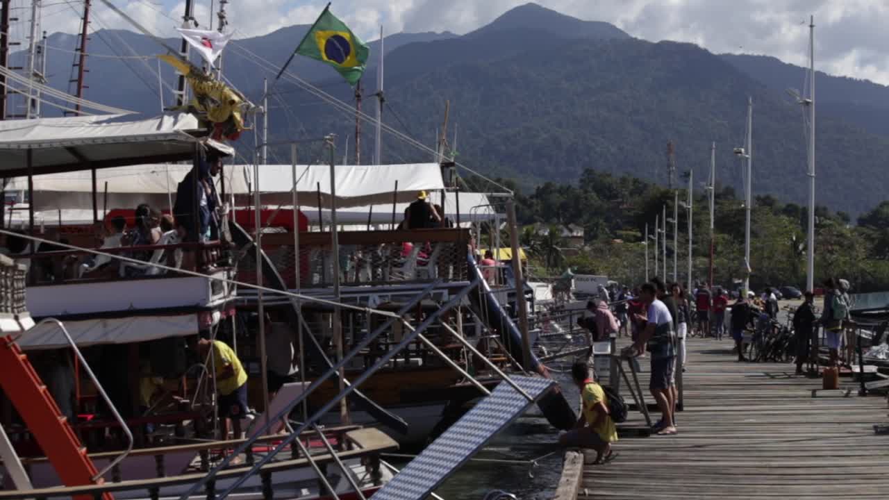 People on wharf loading boats in Paraty, Brazil