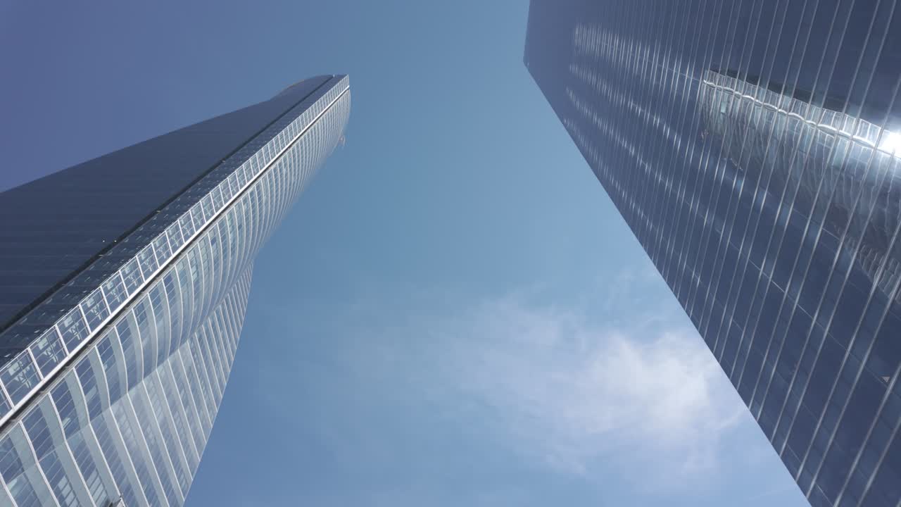 Torre de escritórios alta com fachada de vidro e estrutura limpa